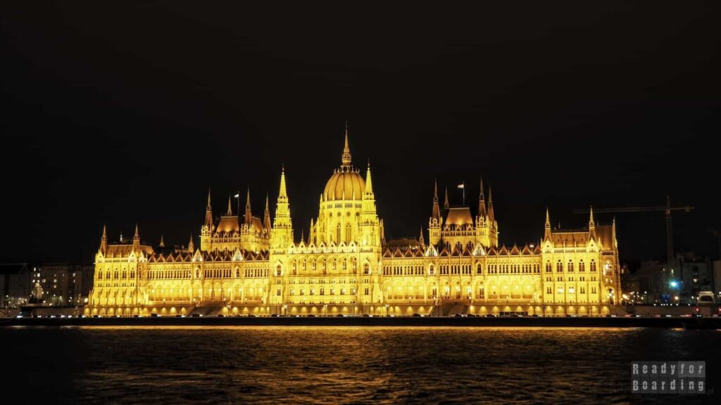 Budynek Parlamentu w Budapeszcie oświetlony nocą nad brzegiem Dunaju