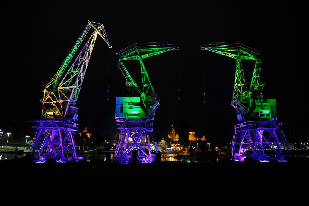 Rozświetlone dźwigozaury na łasztowni w nocy